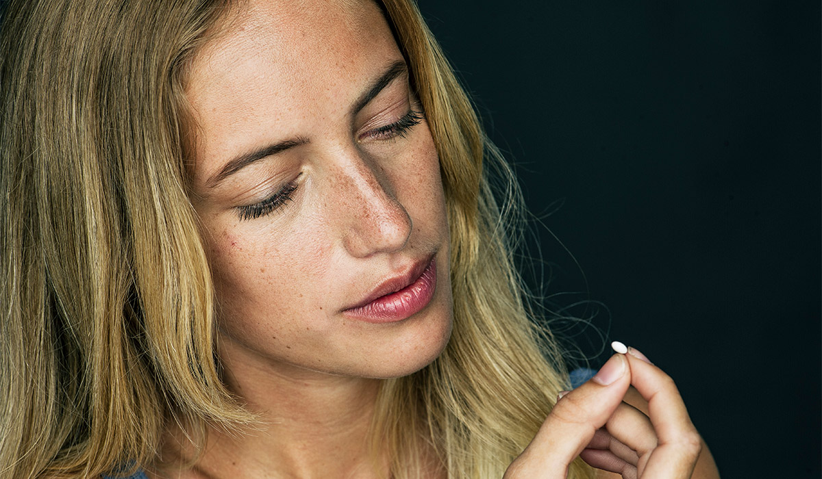 A young woman prepares to take pills